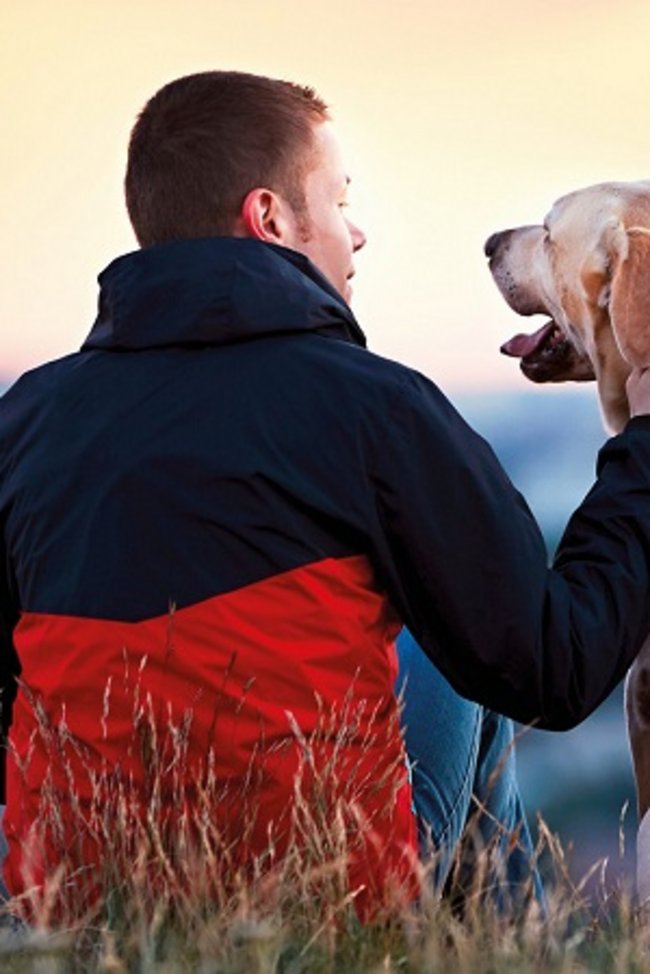 Mann der seinen Hund streichelt