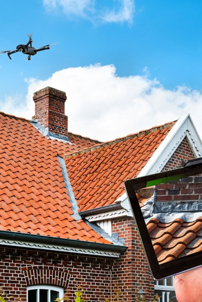 Haus über dem eine Drohne schwebt. Auf einem Bildschirm sieht der Schadensachverständige die Bilder von der Drohne.