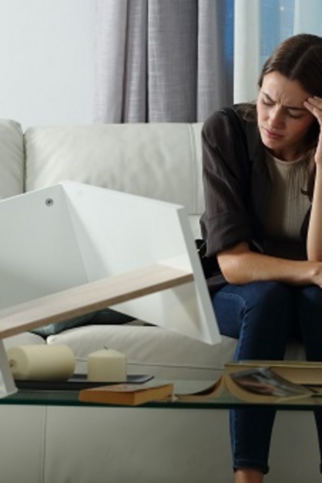 Frau sitzt nach einem Einbruch auf der Couch
