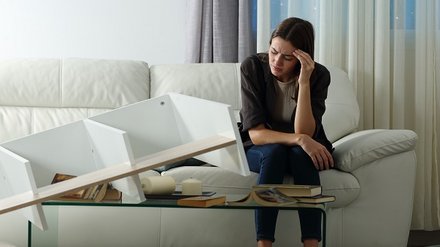 Frau sitzt nach einem Einbruch auf der Couch