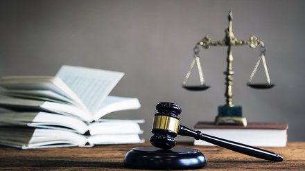 Foto mit einer Waage, einem Anwaltshammer und Büchern